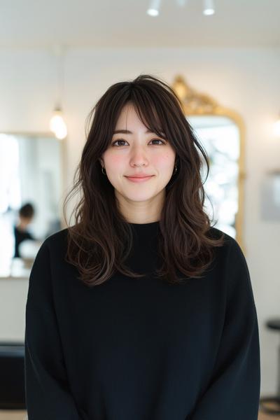 彼女はウルフカットのヘアスタイルで、顔の周りにレイヤーが入り、柔らかく動きを加えた髪型をしています。